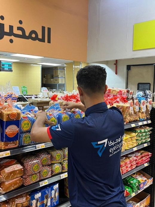 Merchandiser arranging bakery products